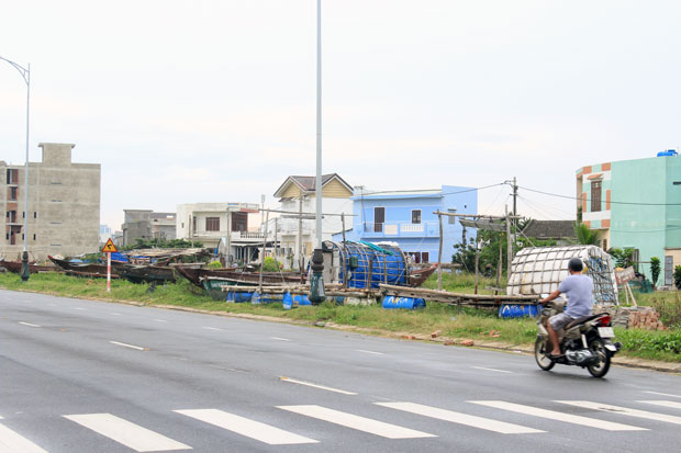 Nhiều tàu, thuyền, lồng bè được tập kết trên vỉa hè ngập cỏ dại, sát lòng đường.      Ảnh: MINH SƠN