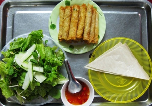 Corn spring rolls are served with vegetables, soft rice paper and a dipping sauce