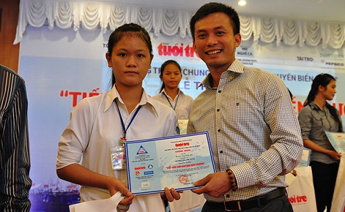  The Secretary of the Da Nang Youth Union, Mr Nguyen Ba Canh, presenting a scholarship to a school pupil (Photo: baomoi)