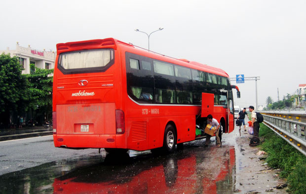 Từ cầu vượt Hòa Cầm đi xuống và đang ôm cua vào quốc lộ nhưng xe khách giường nằm BKS 37B.005.91 vẫn dừng giữa đường để đón khách.