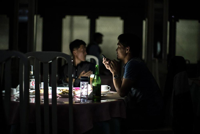 Hai người đàn ông Triều Tiên thưởng thức bữa tối tại một nhà hàng không có điện.
