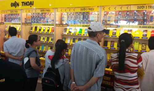 Shoppers choose smartphones at a mobile phone store in Ho Chi Minh City.