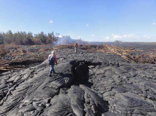 Các nhà địa chất đi trên bề mặt dung nham để theo dõi các dữ liệu bề mặt dung nham bên ngoài làng Pahoa, Hawaii, ngày 22-10-2014. 