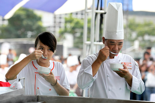 Giám khảo chương trình Masterchef Việt Tuấn Hải và Vua đầu bếp Việt mùa thứ hai Minh Nhật đang nếm thử hương vị của nồi lẩu lớn nhất Việt Nam.