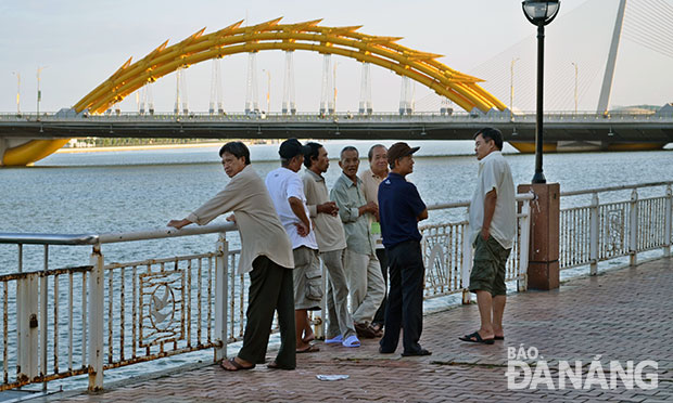 Vỉa hè Bạch Đằng là nơi để dạo mát và trò chuyện. Nơi chuyện vui, chuyện buồn, chuyện trên trời, dưới đất, chuyện thời sự trong nước và quốc tế, chuyện thật, chuyện bịa hòa cùng tiếng cười nói tạo nên khung cảnh yên bình lãng mạn giữa thành phố. (Ảnh: MAI TRANG)