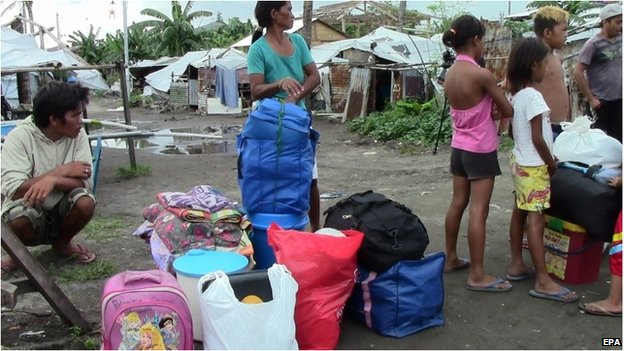 Nhiều người dân Philippines đang chuẩn bị đi tránh bão Hagupit. Phía sau họ là những lều tạm được cất lên từ sau bão Haiyan, cách đây hơn 1 năm.