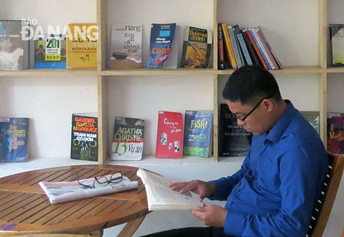  A young man enjoying reading a book at the Omely coffee shop