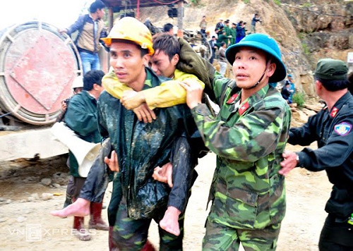 A trapped worker is carried out of the tunnel