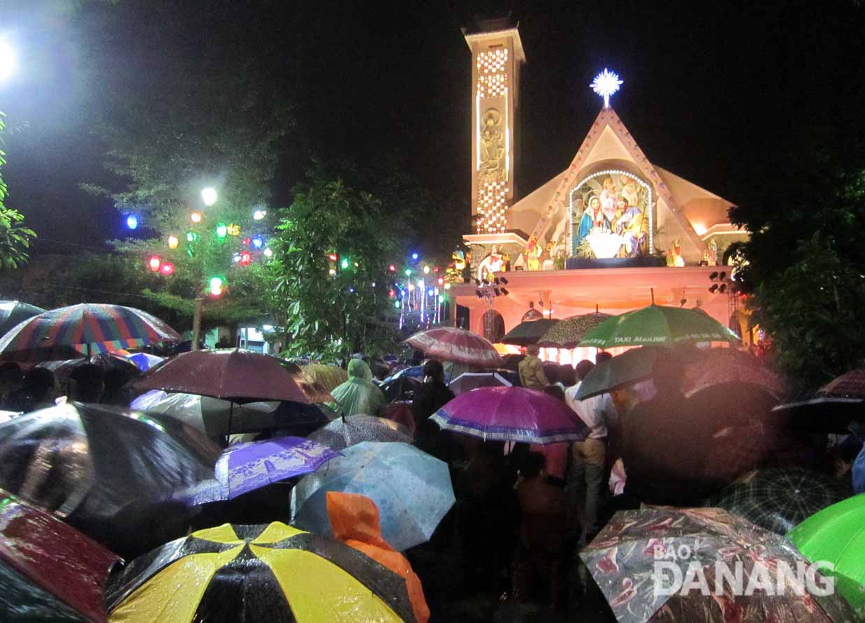 Các giáo dân tại giáo xứ Nhà thờ Thanh Đức đội dù làm lễ dưới cơn mưa mỗi lúc một nặng hạt.