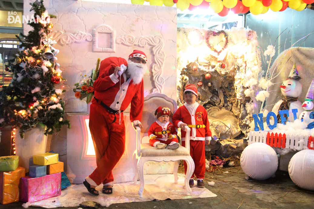 Các em nhỏ hứng thú chụp hình lưu niệm với ông già Noel tại một cửa hàng trên đường Hoàng Diệu.