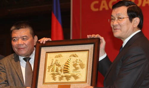 Tran Bac Ha (L), chairman of the Association of Vietnamese Investors in Cambodia, receives a gift from State President Truong Tan Sang 