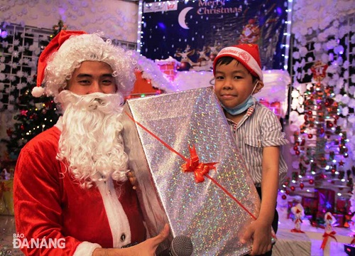    Santa Claus presenting a Christmas gift to a child patient at the Maternity and Paediatrics Hospital