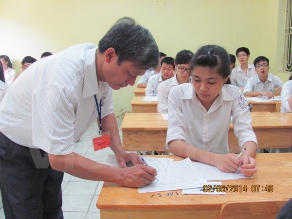 Giám thị ký vào giấy thi cho thí sinh trong kỳ thi tốt nghiệp trung học phổ thông năm 2014.