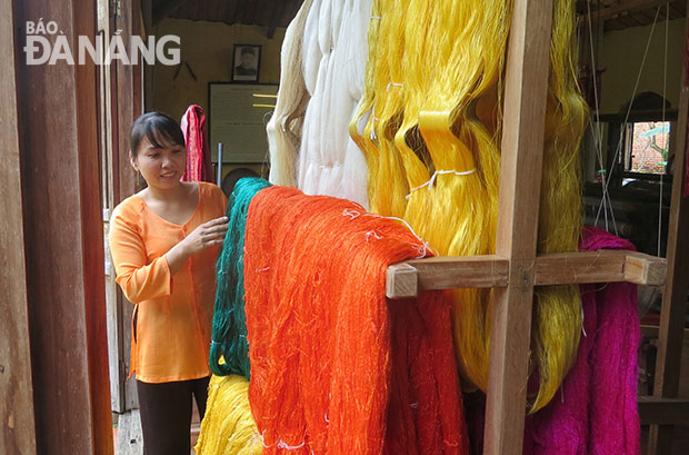 Thợ làng nghề dệt Duy Xuyên giới thiệu công đoạn nhuộm tơ. Ảnh: NGỌC HÀ
