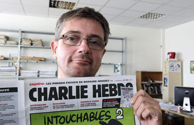 Ông Stephane Charbonnier và tuần báo Charlie Hebdo. 	 			       Ảnh: AP