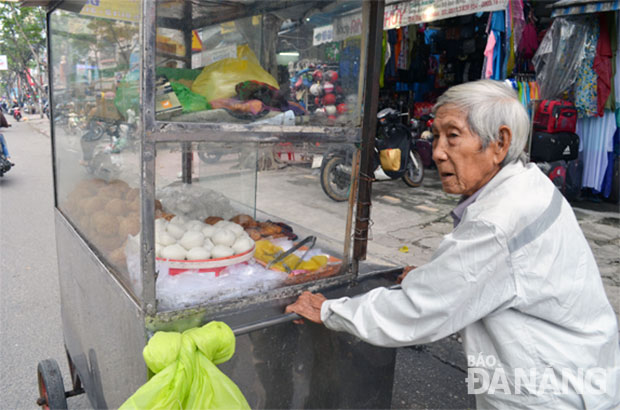 Ông Lý Phú Yên, 88 tuổi và chiếc xe đẩy với các thức quà xưa cũ của mình. Ảnh: M.T