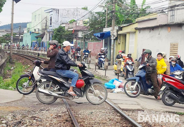 Các đường ngang dân sinh giao cắt với đường sắt luôn tiềm ẩn nguy cơ tai nạn giao thông.  TRONG ẢNH: Người dân tham gia giao thông trên đoạn đường ngang dân sinh giao cắt với đường sắt tại quận Thanh Khê.