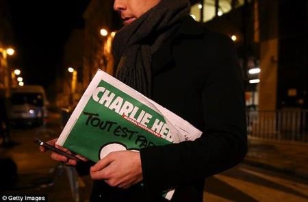 Độc giả cầm trên tay số báo ngày 14-1 của Charlie Hebdo.