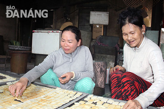 Nghề làm bánh khô mè của gia đình chồng đã gắn bó với chị Thuận(bìa trái) 30 năm nay.  Ảnh: T.Y