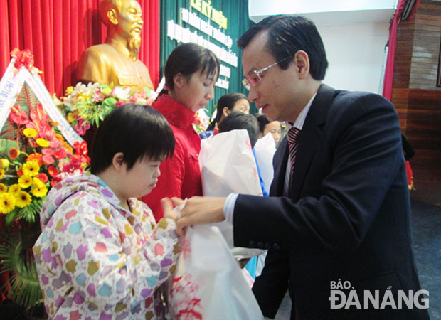 Phó Bí thư Thành ủy Nguyễn Xuân Anh tặng quà cho trẻ em bị nhiễm chất độc da cam.  ảnh: PHƯƠNG TRÀ