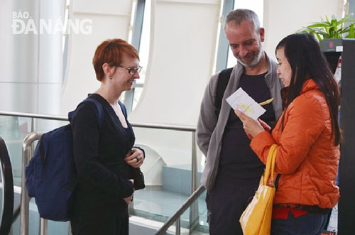  A tour guide (right) collecting feedback from 2 foreign visitors