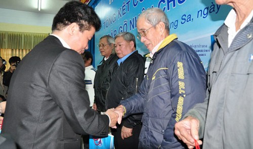 hairman of the Hoang Sa Island District People's Committee Vo Cong Chanh (L) presents gifts to the 