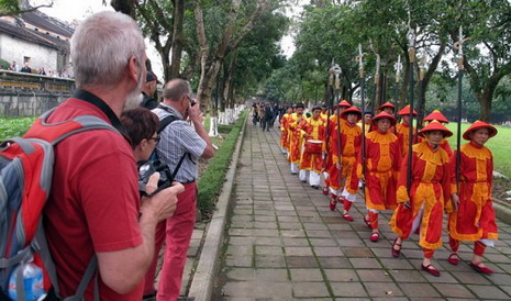 Foreign tourists are shown watching the re-enactment of a royal procession during Tet at Hue Royal Palace in Thua Thien-Hue Province