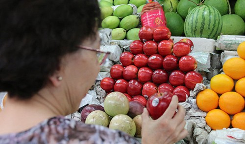 A customer chooses US apples at Ben Thanh Market in Ho Chi Minh City