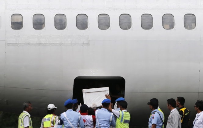 Binh sĩ Indonesia khiêng quan tài chứa thi thể một hành khách lên bờ - Ảnh: Reuters     