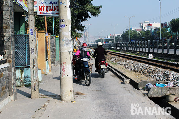 Tại nhiều điểm trên tuyến đường gom ven đường sắt Bắc - Nam hẹp còn bị cột điện cản đường.