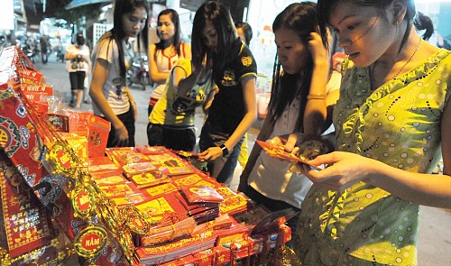 Vietnamese women buying red envelopes for li xi