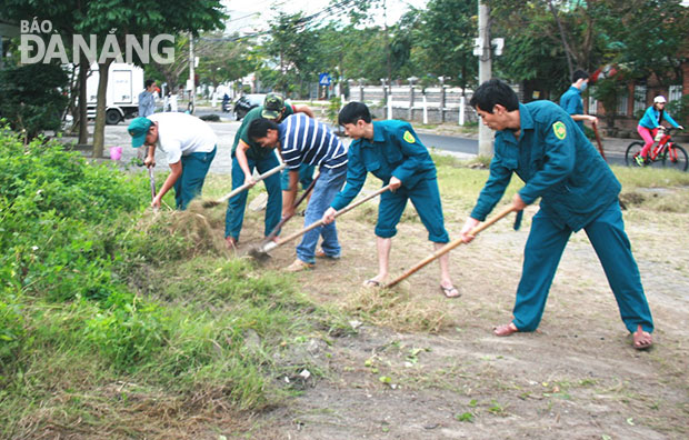 Các lực lượng của phường Hòa Thuận Tây dọn cỏ mọc rậm rạp trên vỉa hè.