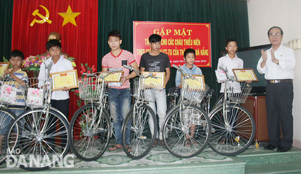 Chủ tịch Hội CCB thành phố Đà Nẵng Thái Thanh Hùng trao xe đạp và quà cho các em.
