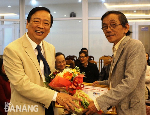 Editor-in-Chief Mai Duc Loc presenting flowers to a freelance journalist