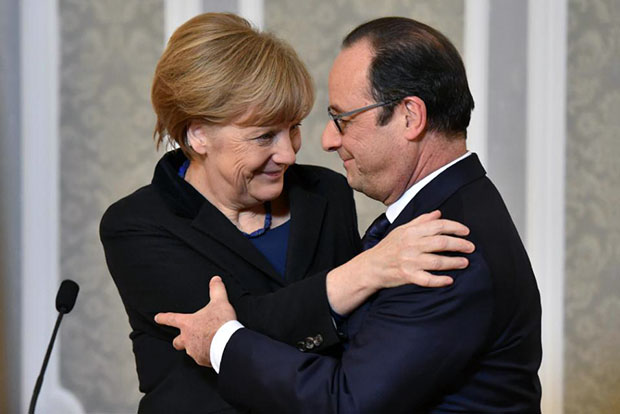 Thủ tướng Đức Angela Merkel và Tổng thống Pháp Francois Hollande chúc mừng nhau khi đàm phán 4 bên đạt được thỏa thuận. Ảnh: AP