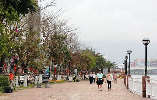    Local residents and visitors walking along the Bach Dang pedestrian promenade …