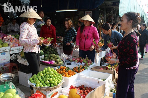 Shoppers buying fruit at a local market