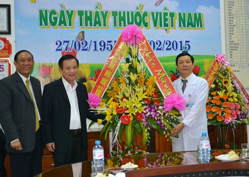 Secretary Tho (second left) presenting flowers to a representative from the hospital