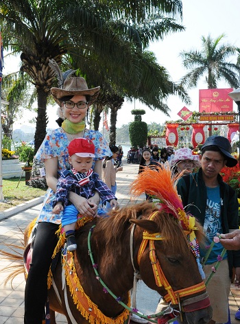 A young mother and her son on a horseback ride