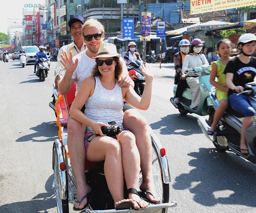    A foreign couple enjoying a city tour by cyclo