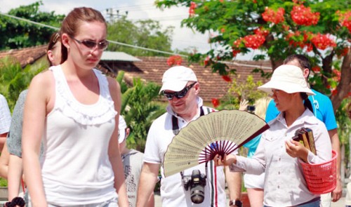 A young peddler is pictured pestering foreign tourists in Nha Trang City