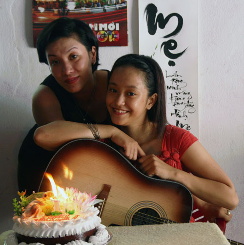 Chị Thu Huyền bên con gái, bánh sinh nhật và đàn ghi-ta. (Ảnh do nhân vật cung cấp)