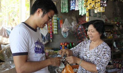 Yoshitaka Ohara, the trip’s organizer, is seen buying “banh trang tron”, a Vietnamese street food commonly eaten by youngsters, on the way to Vietnam’s southern province of Long An. Tuoi Tre News/ Binh MInh