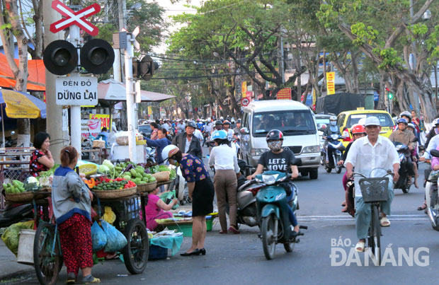 Tình trạng hàng rong bán dưới lòng lề đường, gây cản trở giao thông tại chợ Tam Giác (cũ).