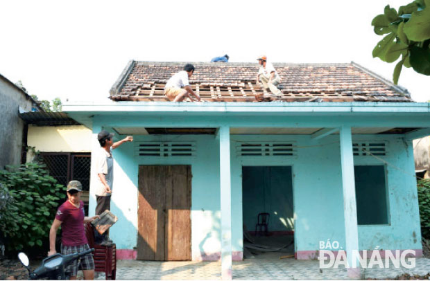 Người dân khu vực Trung Nghĩa, phường Hòa Minh tham gia tháo dỡ nhà họp tổ dân phố để  bàn giao mặt bằng. Ảnh: Triệu Tùng