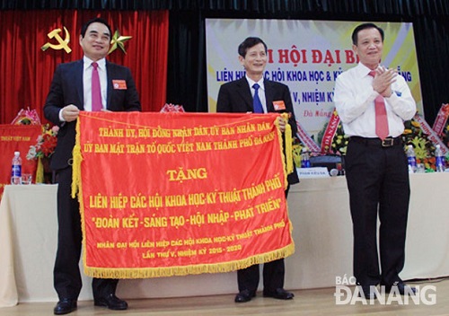 Secretary Tho (first right) presenting an emulation flag to representatives from the Union