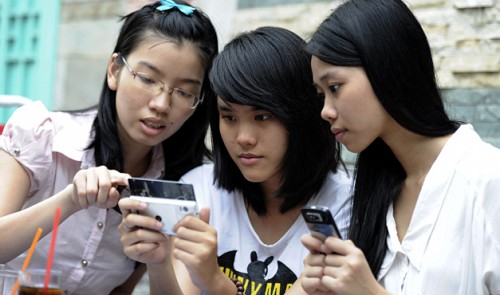 Young Vietnamese girls are seen using mobile phones in Ho Chi Minh City.