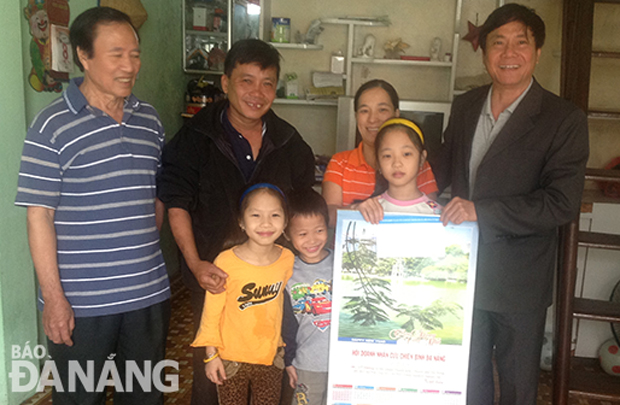 Ông Trần Quang Tuấn (phải) trao quà hỗ trợ cho một gia đình cựu chiến binh ở quận Thanh Khê. (Ảnh nhân vật cung cấp)