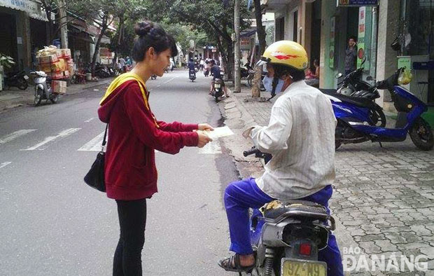 Một bạn trẻ phát tờ rơi cho người đi đường tại thành phố Đà Nẵng.Ảnh: T.Y