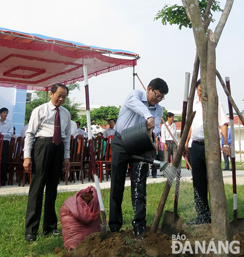 Phó Bí thư thường trực Thành ủy Võ Công Trí trồng cây lưu niệm trong khuôn viên Nhà văn hóa xã Hòa Tiến tại lễ khánh thành.